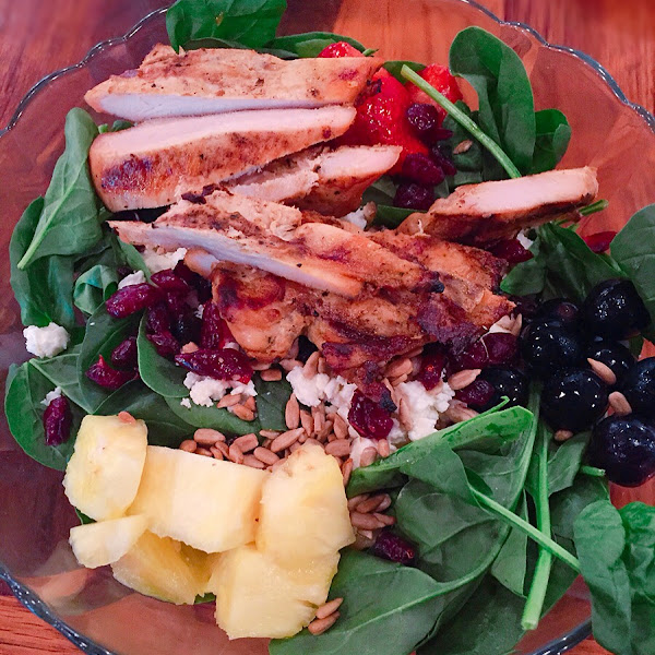 Spinach salad w/ pineapple, grapes, strawberries, dried cranberries, feta cheese, & perfectly marinated grilled chicken. Loved it!