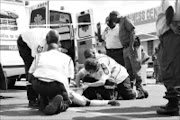 INJURED: Paramedics attend to Constable Khathutshelo Ramabenyane who was knocked down by a government car. 23/12/08. Pic. Chester Makana. © Sowetan.