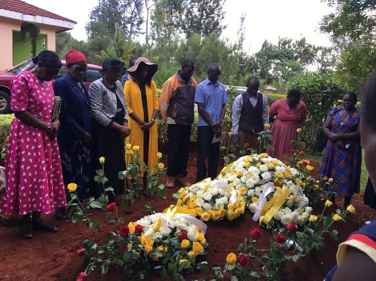 Family members gather around the grave of the late Engineer Maurice Namiinda