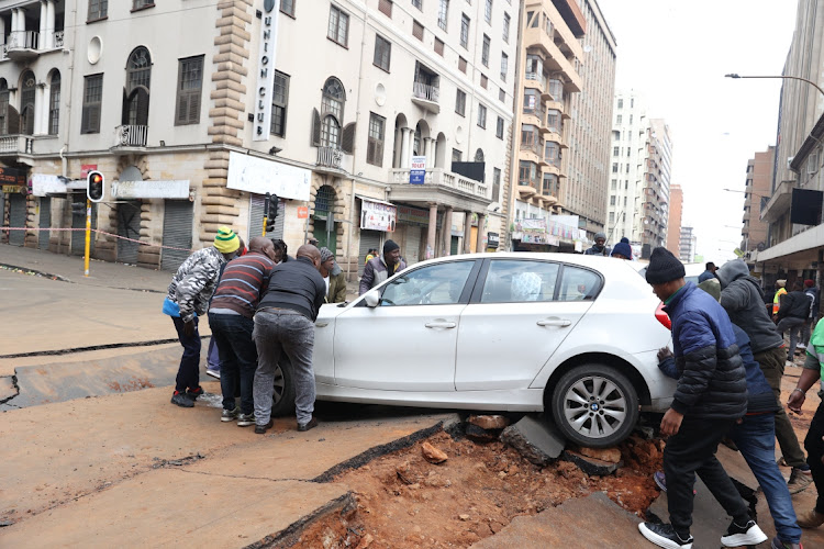 Mmembers of the public help untangle a car from the rubble of Lillian Ngoyi street after an explosion that hit the Johannesburg CBD on Wednesday.