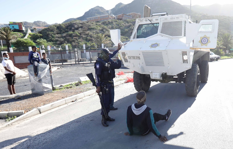 A protecting west coast lobster rights holder from Hangberg blocks the path of a police vehicle on June 23 2020.