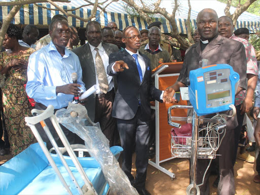 Kabondo-Kasipul MP Silvance Osele (in blue tie) and Rev David Chuchu hand over medical equipment worth Sh25 million to the Kabondo Subcounty Hospital in January as residents look on / MAURICE ALAL