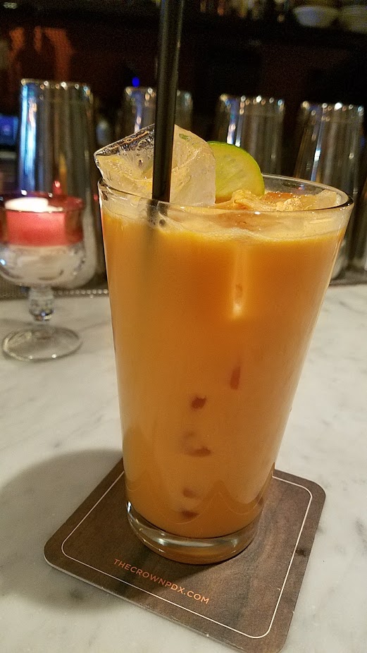 The Crown PDX A Thai Stick Cooler cocktail offers lemongrass, lime leaf, galangal infused vodka, Thai tea, coconut, and lime