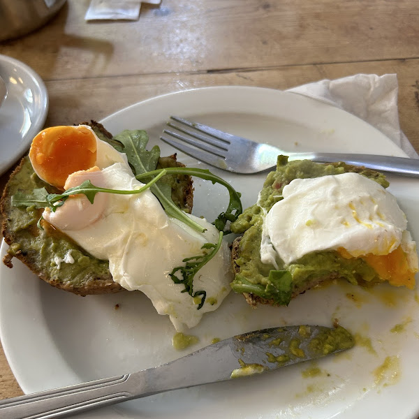 Smashed avocado with chili on a gf bread roll, with poached eggs.