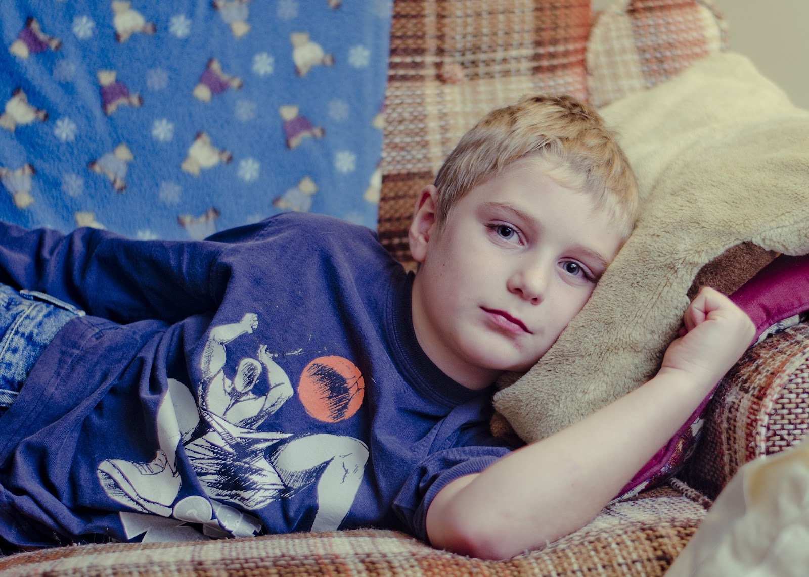 Image of a little boy laying on the couch