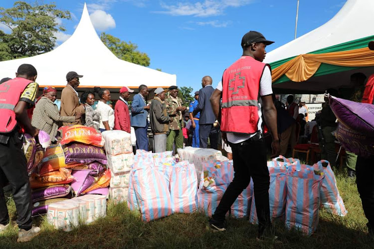 Floods and landslides victims queue to receive relief food at Ihura stadium.
