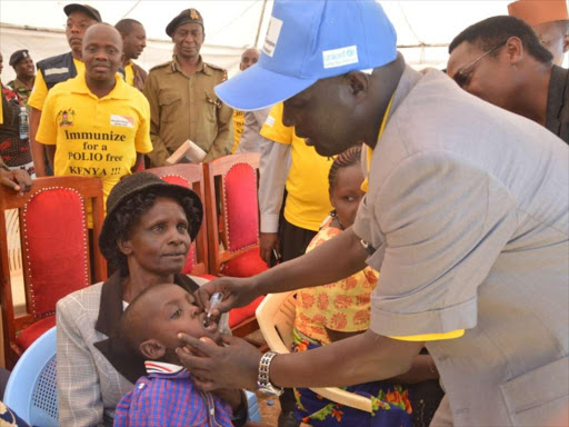 HEALTHY: West Pokot Governor Simon Kachapin gives drops of polio vaccine to a child in Kapenguria town during the launch of the campaign on Saturday.