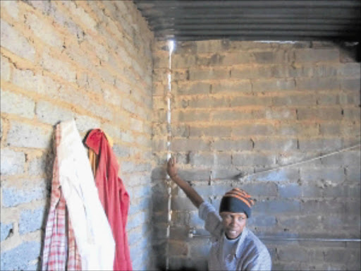 DAILY RISK: Othilia Mabolotsane of Matoporong, Reddersberg in Free State, points at some of the cracks on the walls of her incomplete RDP house, which she says can collapse at any time. PHOTO: NTWAGAAE SELEKA