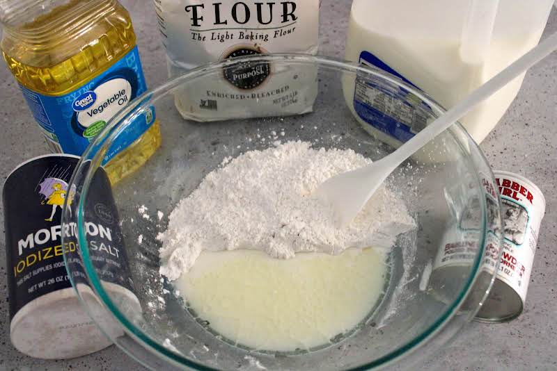 Sifted Flour, Baking Powder, Salt,  Milk, And Salad Oil In A Bowl. 