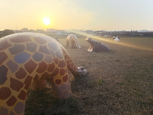 うなだれるキリンたちと土に埋もれるカバ