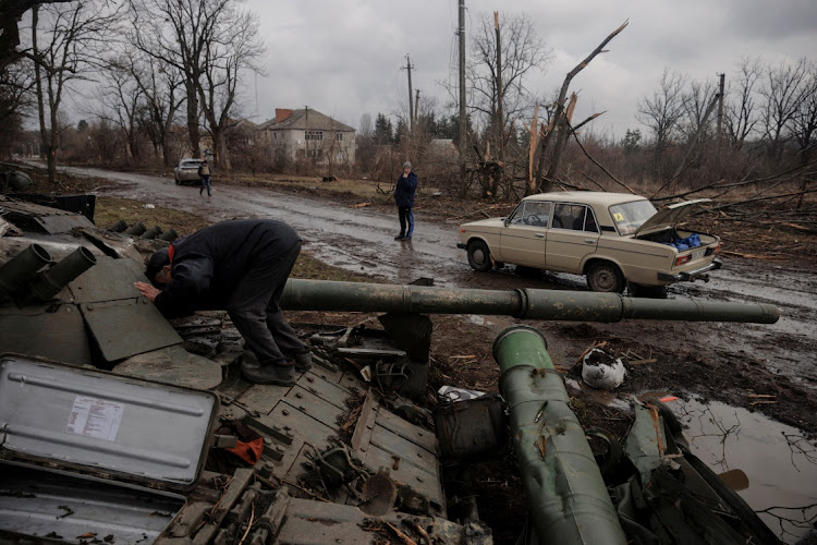 A local man looks into a Russian tank left behind after Ukrainian forces expelled Russian soldiers from the town of Trostyanets which they had occupied at the beginning of its war with Ukraine, March 30 2022. Picture: REUTERS/THOMAS PETER