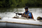 A naval security operative patrols the creeks of the Niger Delta in a military gun boat. File photo