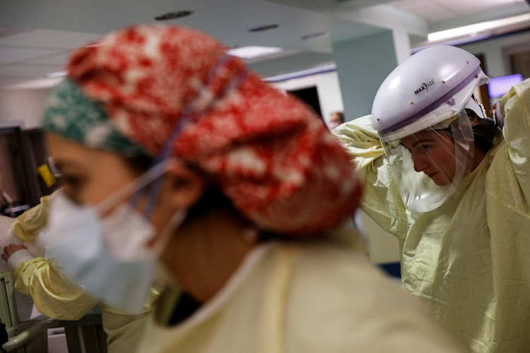 Medical staff prepare to enter the isolation room of a Covid-19 patient in the intensive care unit at Western Reserve Hospital in Cuyahoga Falls, Ohio, US on January 4 2022.