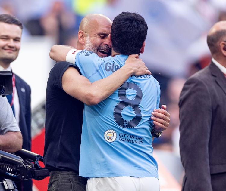 City's manager Pep Guardiola (L) celebrates with Ilkay Gundogan after the FA Cup Final match