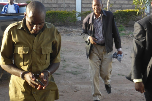 EACC officers escort the handcuffed policeman caught receiving bribe from a motorist at Archers Post Samburu County. Photo/Courtesy