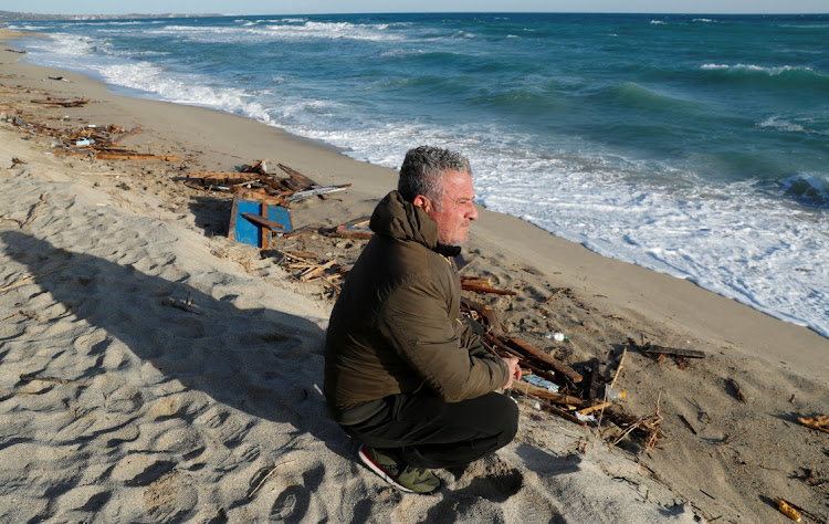 Fisherman Vincenzo Luciano sits among the debris from the ship in the aftermath of a deadly migrant shipwreck in Steccato di Cutro, near Crotone, Italy, March 1 2023. Picture: REUTERS/REMO CASILLI.