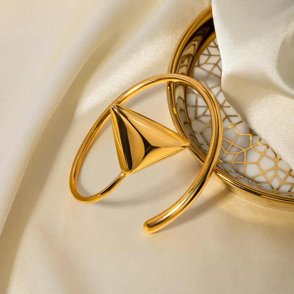 Brazalete de espiral triangular de acero inoxidable con baño de oro de 18K, elegante y moderno. Perfecto para cualquier ocasión.