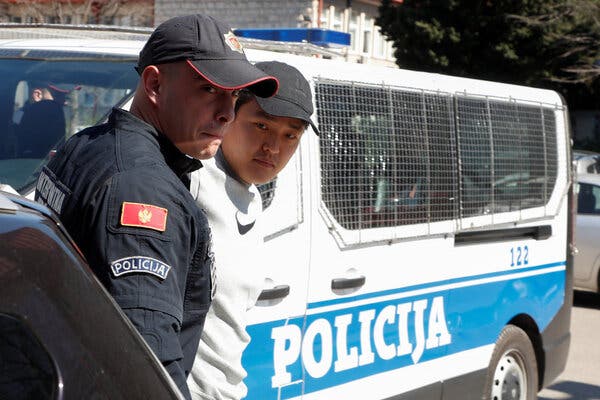 Two men in caps in front of a blue and white van.