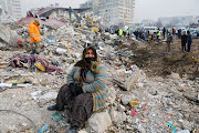 A woman reacts at the site of a collapsed building as the search for survivors continues, in the aftermath of a deadly earthquake in Kahramanmaras, Turkey February 10, 2023.