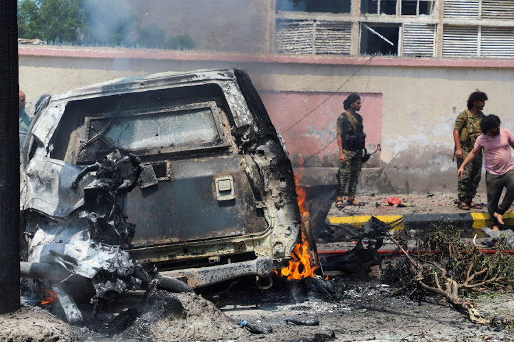 Policemen stand at the scene of a blast in Aden, Yemen, October 10, 2021.