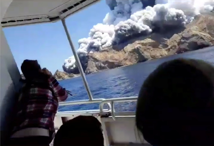 NARROW ESCAPE: Passengers on a boat watch smoke billows from the volcanic eruption of Whakaari, also known as White Island, in New Zealand on Monday in this screen grab obtained from a social media video