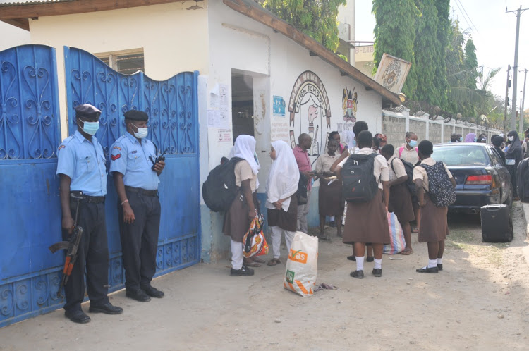 Police stand guard outside the main gate of the Mama Ngina Girls Secondary School after the students were sent home after an attempted arson. Photo/LABAN WALLOGA