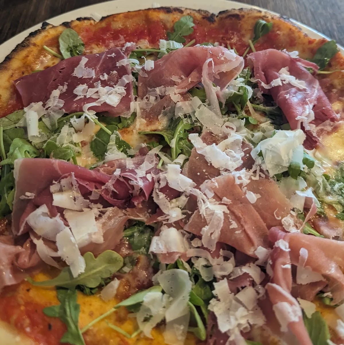 GF pizza with prosciutto, mozzarella, parmesan and arugula