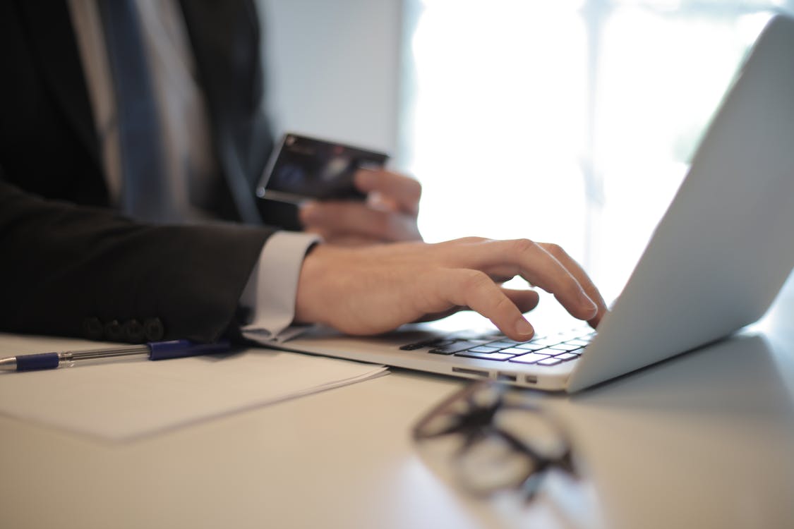 Person in Black Suit Typing on a Computer