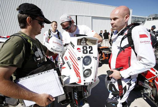 epa04549001 (FILE) A file photo dated 03 January 2015 shows Polish rider Michal Hernik (R) of KTM attending the technical review prior to the Rally Dakar 2015 in Buenos Aires, Argentina. The Dakar Rally runs from 03 to 17 January 2015. Reports on state that Michal Hernik died on 06 January 2015 while compiting in the third stage of the Rally, between San Juan and Chilecito, Argentina. EPA/FELIPE TRUEBA