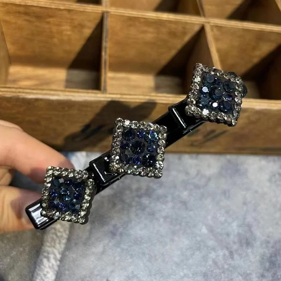 Presilha bico de pato trançada com dois strass quadrados. Prenda o cabelo com estilo, adicionando brilho e um toque sofisticado para qualquer look.