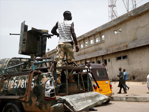 A soldier stands behind a machine gun on a truck along a road in Nigerian northern city of Maiduguri, June 7, 2017.