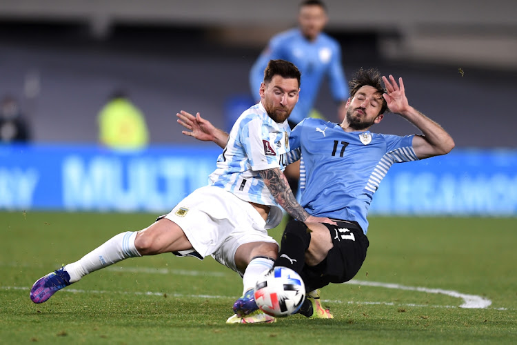 Lionel Messi of Argentina fights for the ball with Matias Viña of Uruguay during their South American Qualifier for Qatar 2022 at Estadio Monumental Antonio Vespucio Liberti on October 10, 2021 in Buenos Aires