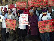 Gogo Mviko, holding a poster that reads 