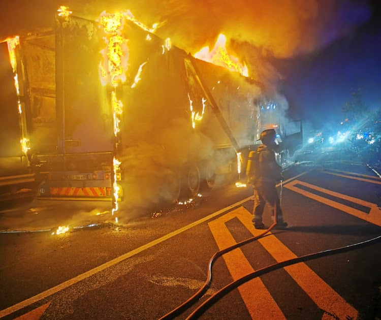 Three men forced the driver at gunpoint to get out of the truck, then petrol-bombed it.