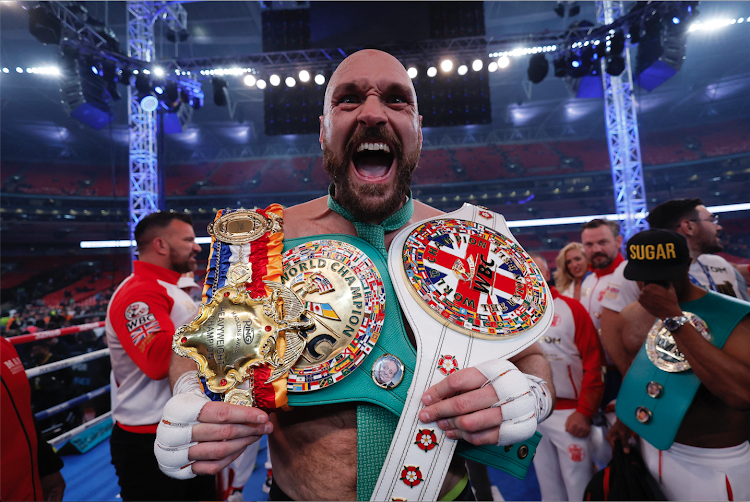 Tyson Fury celebrates with the belts after his win against Dillian Whyte