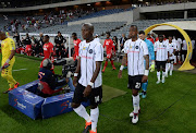 Players and officials walking to the field during the MTN 8, quarter final match Orlando Pirates and Highlands Park at Orlando Stadium on August 17, 2019 in Johannesburg, South Africa. 