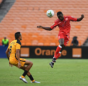 Alseny Camara of Horoya AC challenged by Kearyn Baccus of Kaizer Chiefs during the 2021 CAF Champions League match between Kaizer Chiefs and Horoya AC on the 23 February 2020 at FNB Stadium.