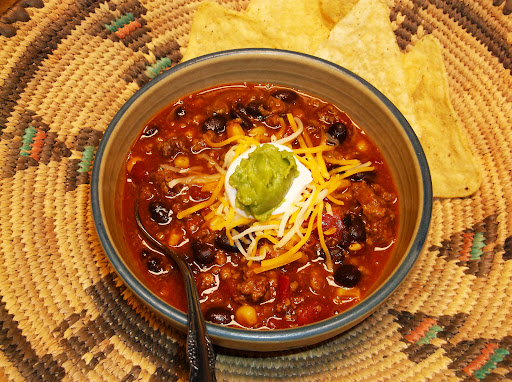 Taco soup topped with cheese, sour cream and guacamole. 