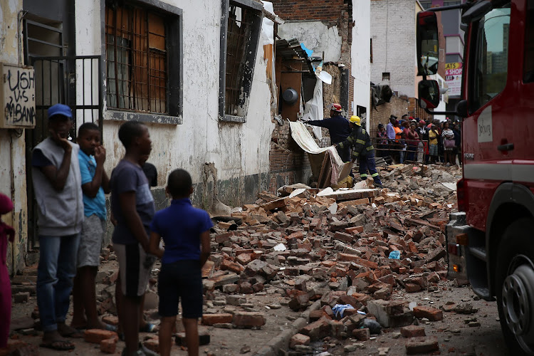 Relatives mourn the loss of young children, after a wall collapsed onto them while they were playing, in Doornfontein, Johannesburg.