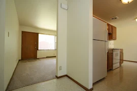 Apartment entryway open to the living room and leading to the ktichen 