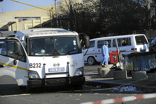 A police forensic officer combs the scene for evidence at Bara taxi rank after robbers attacked a cash van that was loading ATMs in the area and stole an undisclosed amount of money. /Veli Nhlapo