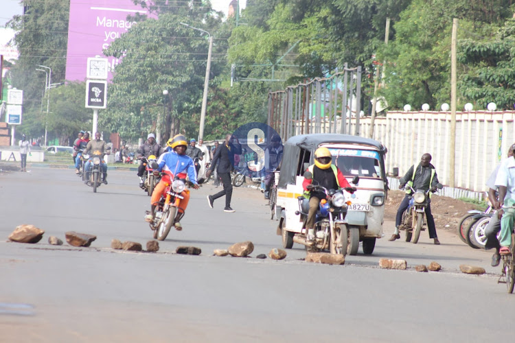 Motorists pass through barriers mounted by Azimio La Umoja protesters on March 27, 2023.