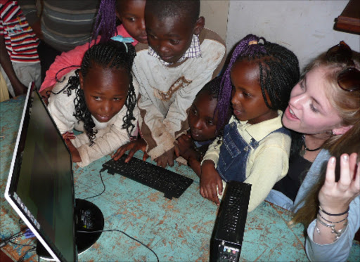 A group of children from Huruma slum, Nairobi, learn using a desktop