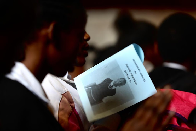 A Forest High School pupil holds a program at the memorial service of Daniel Bakwela who was allegedly stabbed and killed by a fellow pupil.