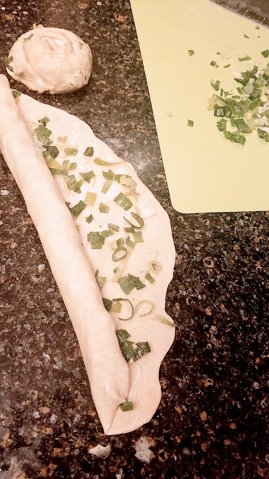 Recipe for Green Onion Pancake, also known as Scallion Pancakes Recipe - Roll each of the rectangles now brushed with sesame oil and sprinkled with scallions into a long tube