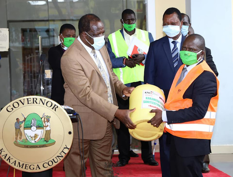 Kakamega Governor Wycliffe operanya receives sanitiser from KCCI kakamega branch.