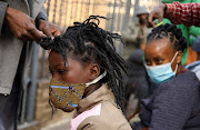 Customers are attended to by roadside hairdressers, openly flouting lockdown regulations amid the spread of the coronavirus disease (COVID-19), in Johannesburg. File photo. 