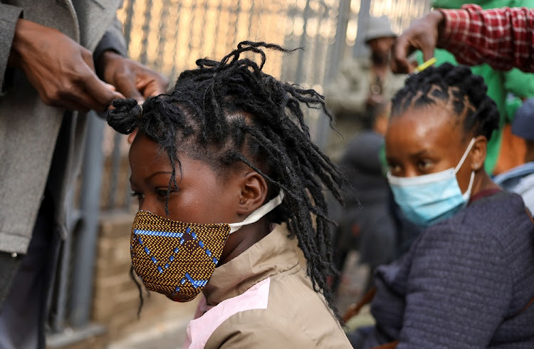 Customers are attended to by roadside hairdressers, openly flouting lockdown regulations amid the spread of the coronavirus disease (COVID-19), in Johannesburg, South Africa, June 6 2020.