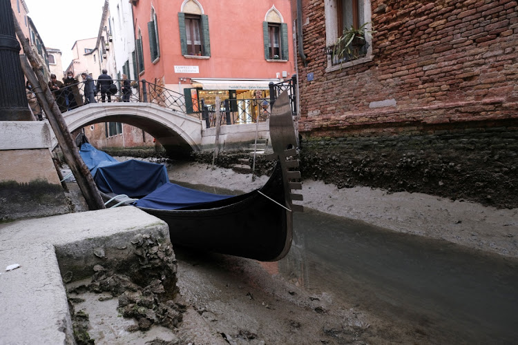 A gondola is pictured in a canal during a severe low tide in the lagoon city of Venice, Italy, March 17, 2022.