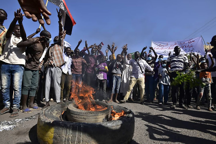 People gesture and chant slogans as they protest against the military coup in Sudan, in "Street 60" in the east of capital Khartoum on November 13, 2021.